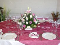 Guest table flower arrangement on burgundy organza overlay